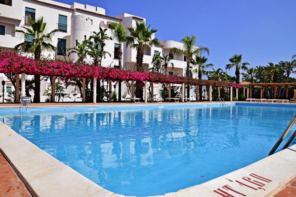 une grande piscine devant un immeuble dans l'établissement Saracen Sands Hotel & Congress Centre - Palermo, à Isola delle Femmine