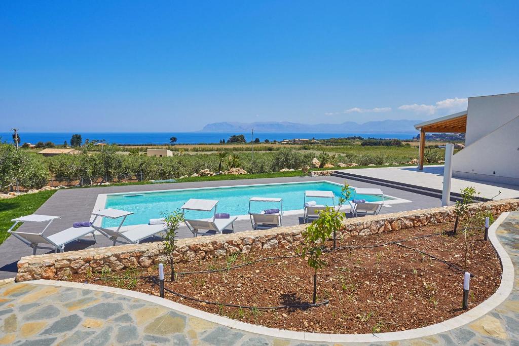 une piscine dans une cour avec des chaises autour dans l'établissement Villa dell'Artista, à Scopello