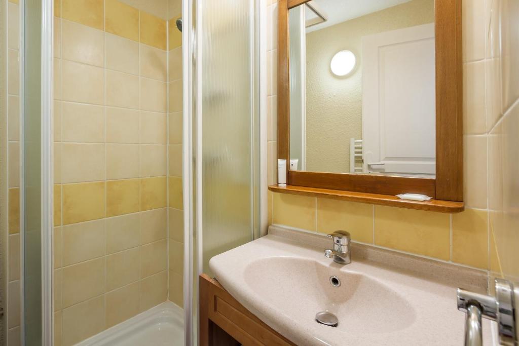 une salle de bain avec un lavabo et une douche dans l'établissement Résidence Pierre & Vacances Pyrenees 2000 Le Séquoia, à Bolquère-Pyrénées 2000