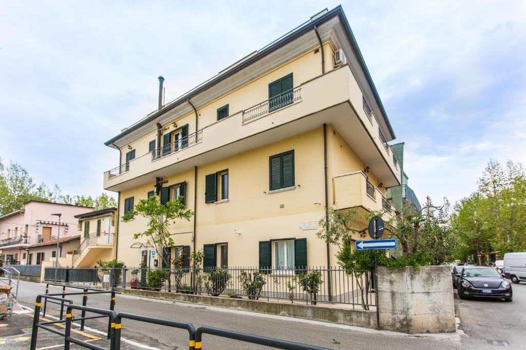 un bâtiment jaune avec des fenêtres noires dans une rue dans l'établissement Residence Kimba, à Rimini