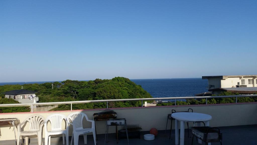 un balcon avec des chaises blanches et une vue sur l'océan dans l'établissement Hanayukaku, à Shima