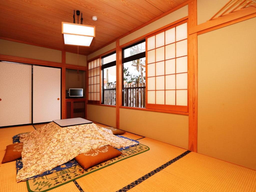 Cette chambre dispose d'un lit et de fenêtres. dans l'établissement Minshuku Kojima, à Nozawa Onsen