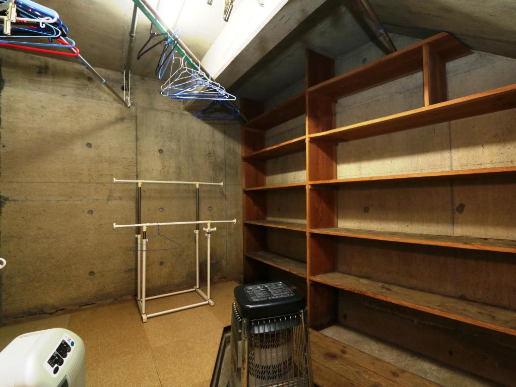 Cette chambre dispose d'étagères en bois et d'une douche. dans l'établissement Minshuku Kojima, à Nozawa Onsen 37 autres photos