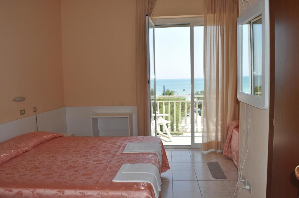 une chambre avec un lit et une vue sur l'océan dans l'établissement Hotel Perla, à Senigallia