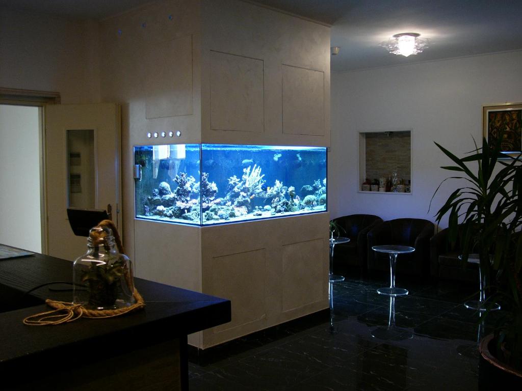 - un grand aquarium dans une pièce avec une table et des chaises dans l'établissement Hotel Lido, à Deiva Marina