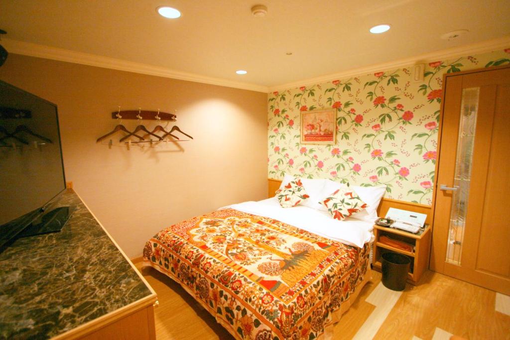 - une chambre avec un lit orné d'un mur fleuri dans l'établissement Aura Kanku (Adult Only), à Sennan