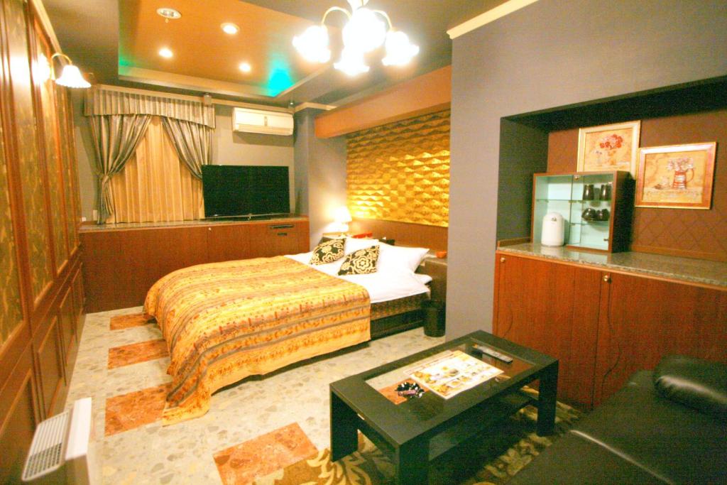 une chambre d'hôtel avec un lit et une table dans l'établissement SARI Resort Kawanishi (Adult Only), à Kawanishi