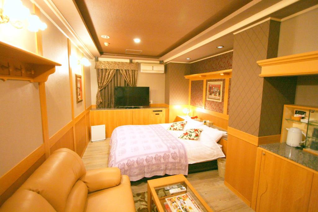 une chambre d'hôtel avec un lit et un canapé dans l'établissement SARI Resort Kawanishi (Adult Only), à Kawanishi