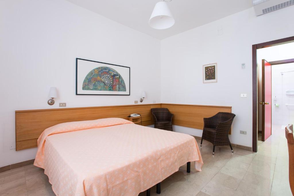 une chambre avec un lit, une table et des chaises dans l'établissement Hotel Mediterraneo, à Vieste