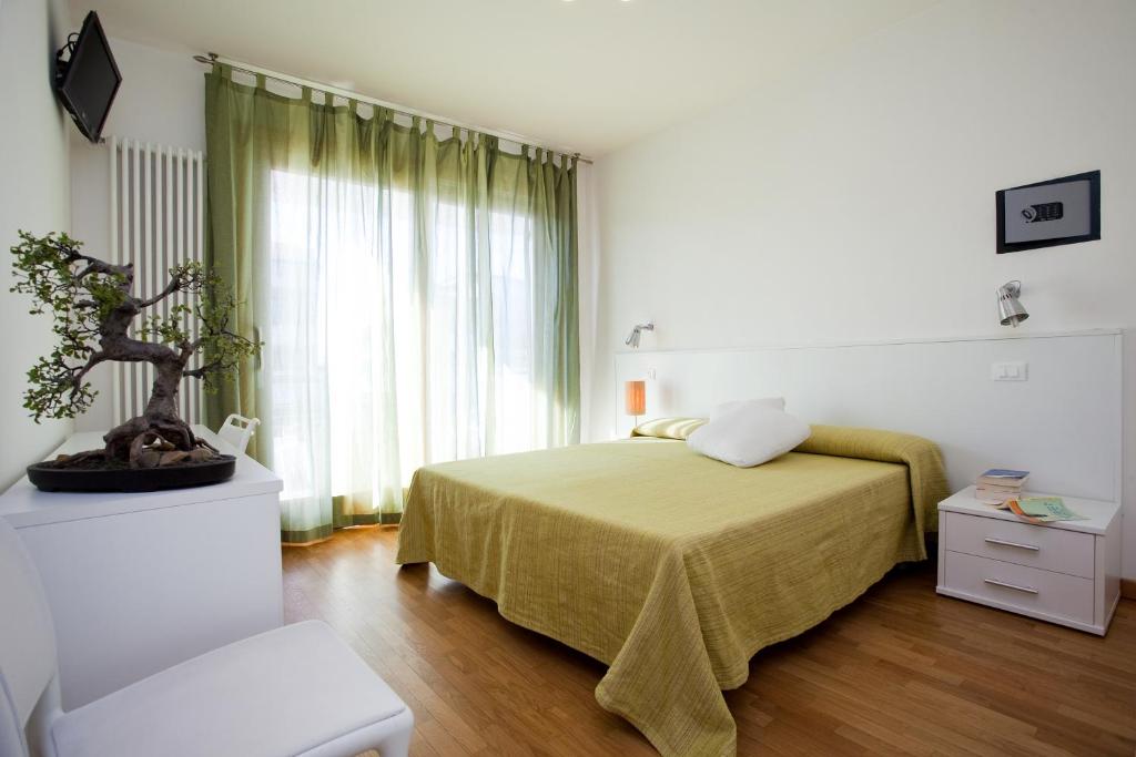 une chambre avec un lit et une grande fenêtre dans l'établissement Residence Speranza, à Lido di Jesolo