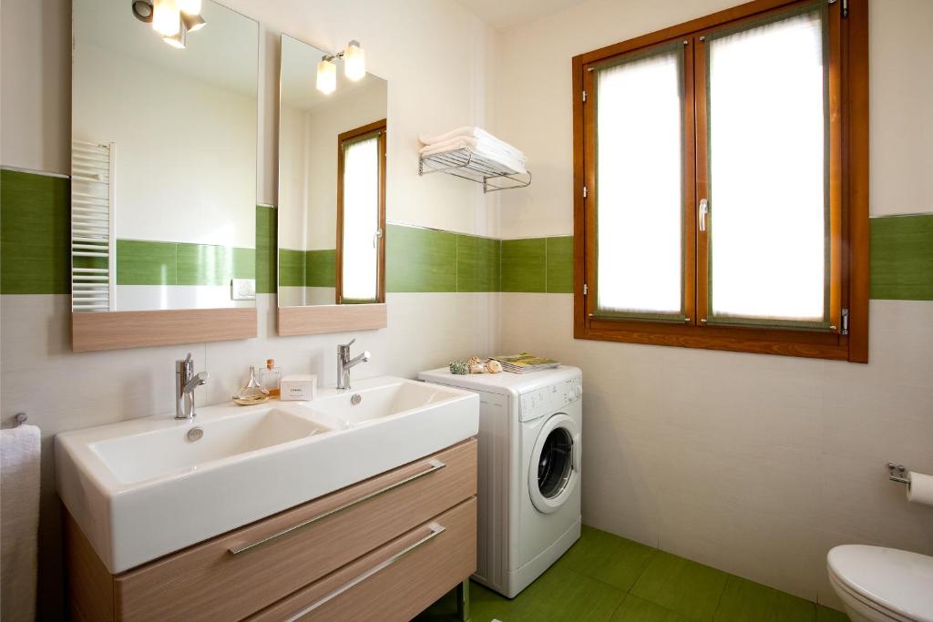 une salle de bain avec un lavabo et une machine à laver dans l'établissement Residence Speranza, à Lido di Jesolo 20 autres photos