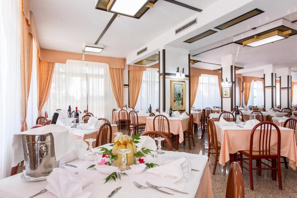 une salle à manger avec des tables et des chaises blanches dans l'établissement Hotel Mediterraneo, à Vieste
