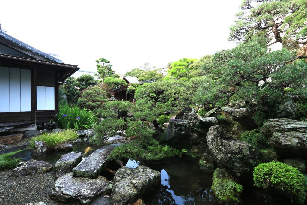 un jardin avec des rochers et des arbres devant une maison dans l'établissement Shunkouen, à Usuki