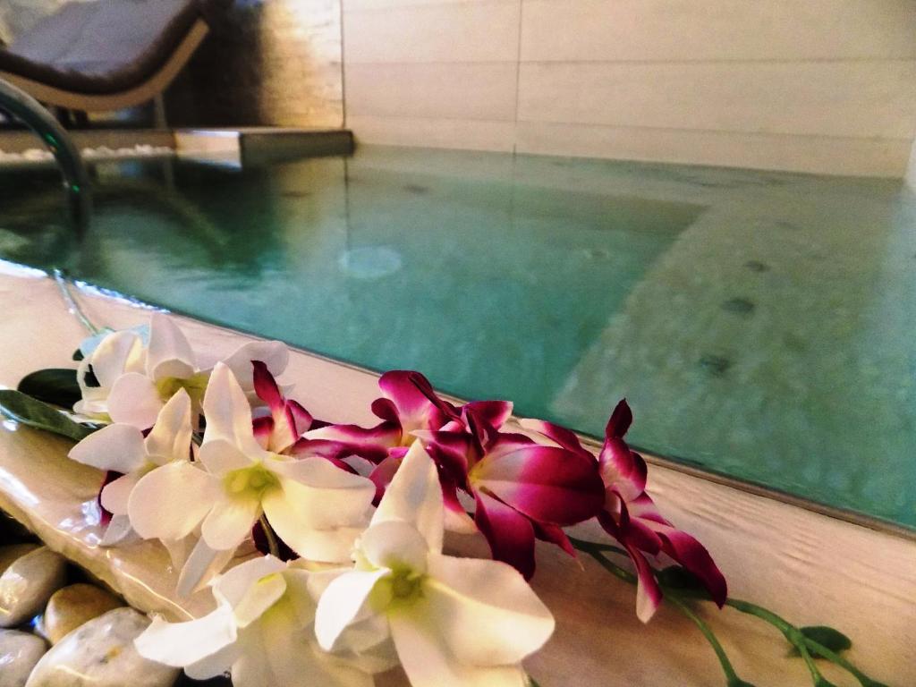 - un bouquet de fleurs assis à côté de la piscine dans l'établissement Hotel Residence Villa Del Mare, à Rimini