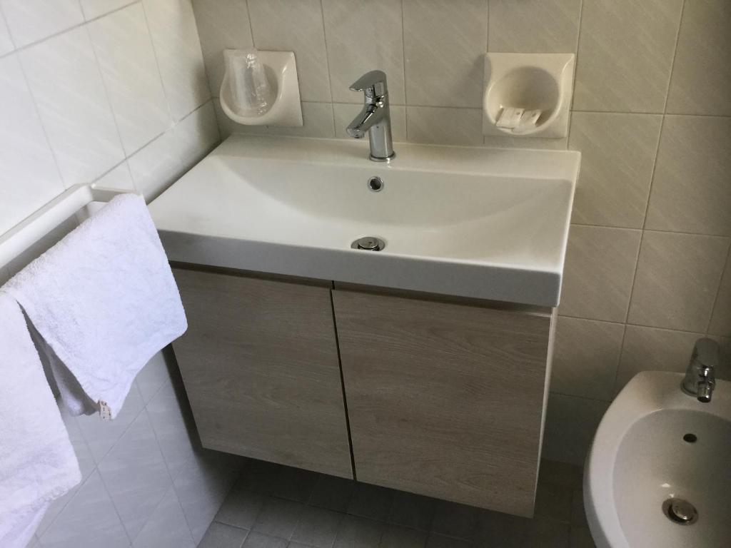 une salle de bain avec un lavabo et des toilettes dans l'établissement Acapulco Beach, à Lido di Jesolo 52 autres photos