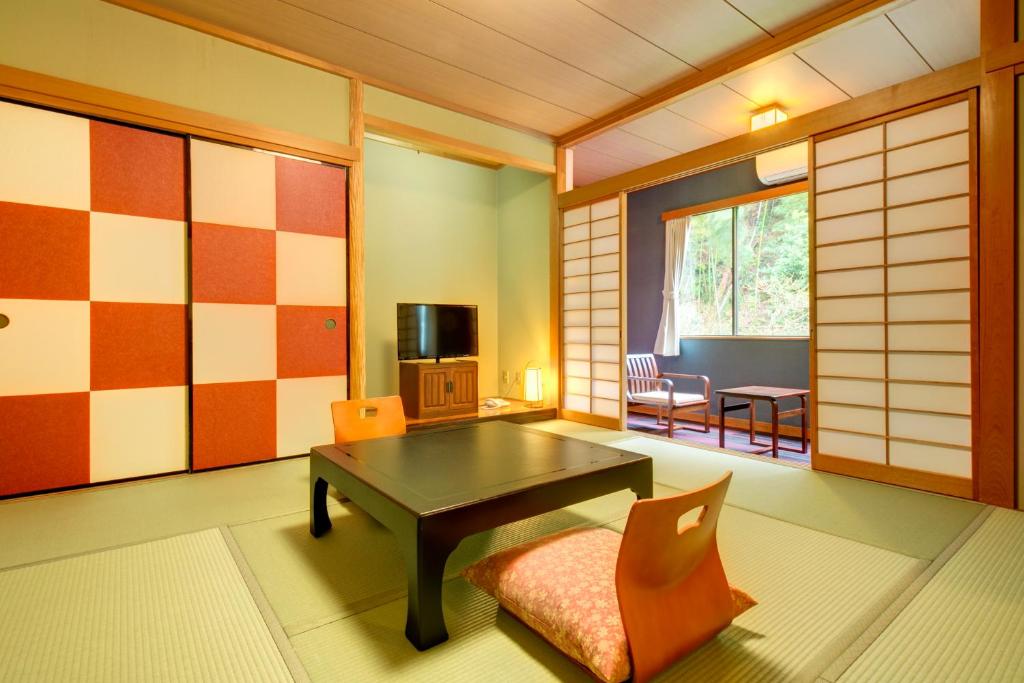 un salon avec une table et une chaise dans l'établissement Yugawara-Onsen Komachikan, à Yugawara