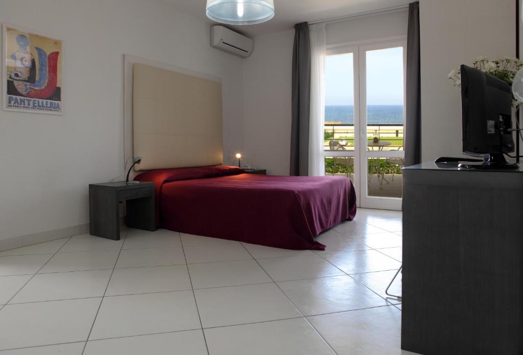 une chambre avec un lit et une vue sur l'océan dans l'établissement Brezza Di Grecale, à Trapani