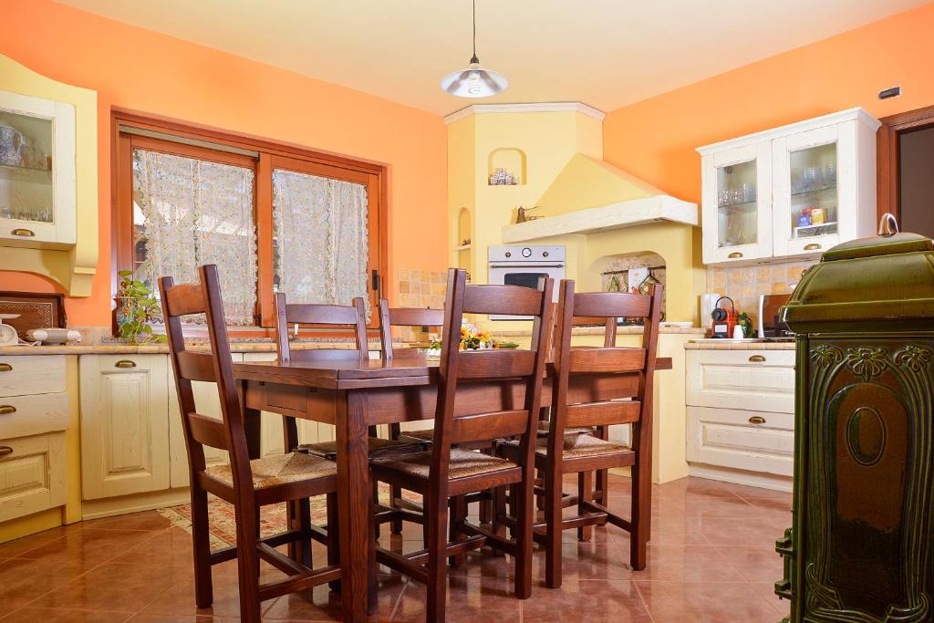 une cuisine avec une table et des chaises en bois dans l'établissement Villa nevada -20 min da Roma, à Ladispoli