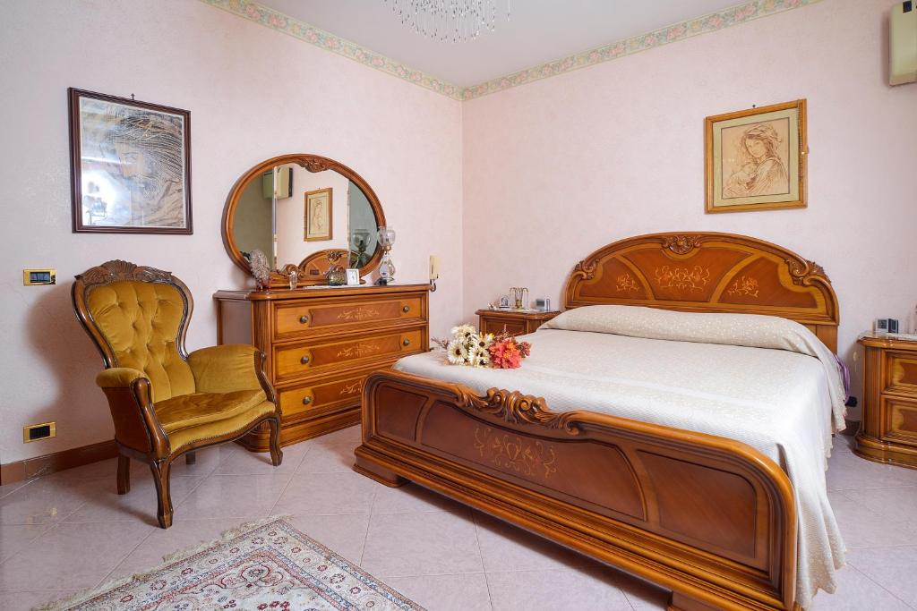 une chambre avec un lit, une chaise et un miroir dans l'établissement Villa nevada -20 min da Roma, à Ladispoli 32 autres photos