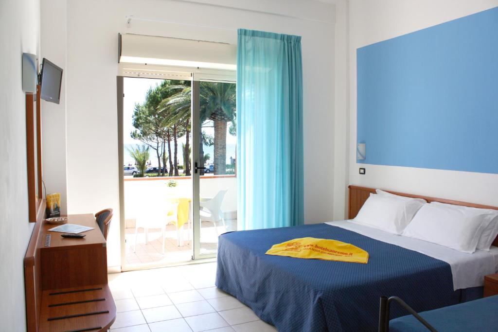 une chambre avec un lit et une porte coulissante en verre dans l'établissement Hotel San Remo - All Inclusive - Fronte Mare - Spiaggia Privata, à Martinsicuro
