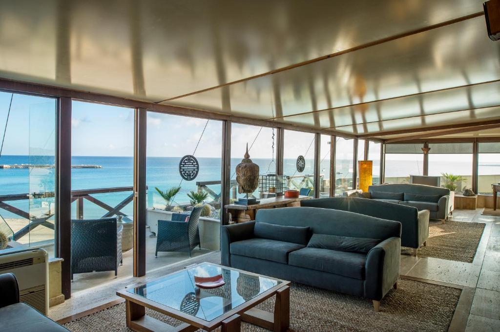 - un salon avec canapés et vue sur l'océan dans l'établissement Hotel Capo San Vito by Geocharme, à San Vito Lo Capo