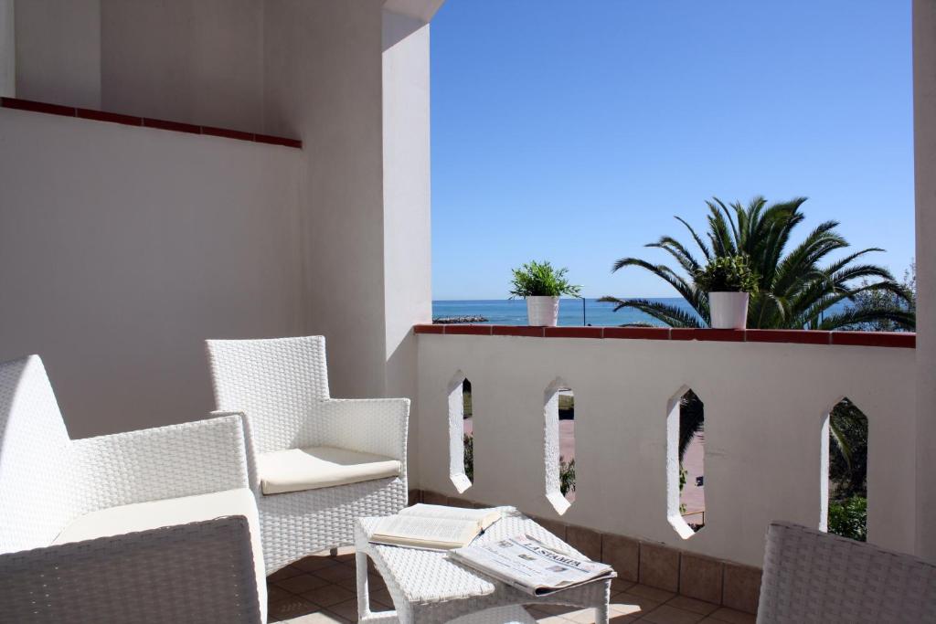 d'un balcon avec des chaises et une table offrant une vue sur l'océan. dans l'établissement Hotel San Remo - All Inclusive - Fronte Mare - Spiaggia Privata, à Martinsicuro