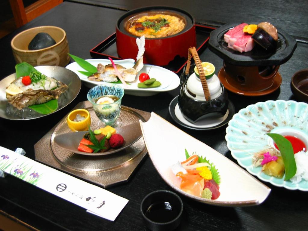 une table avec des assiettes de nourriture sur une table dans l'établissement Noren Yado Meigetsu, à Tsuwano 30 autres photos