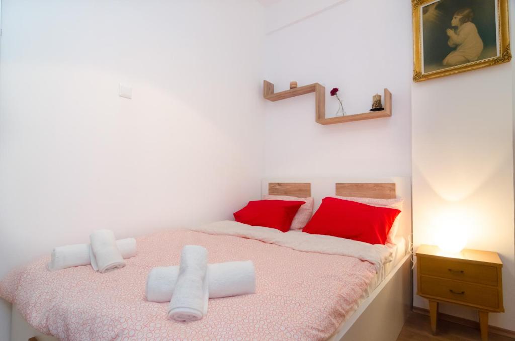 a bedroom with a bed with red and white pillows at Aristotelous street small apartment in Thessaloniki