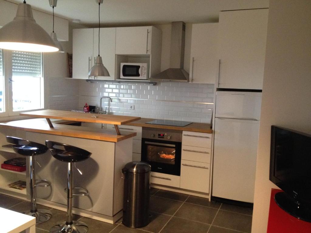 a kitchen with white appliances and a stove top oven at K&A Apartment in Aulnay-sous-Bois