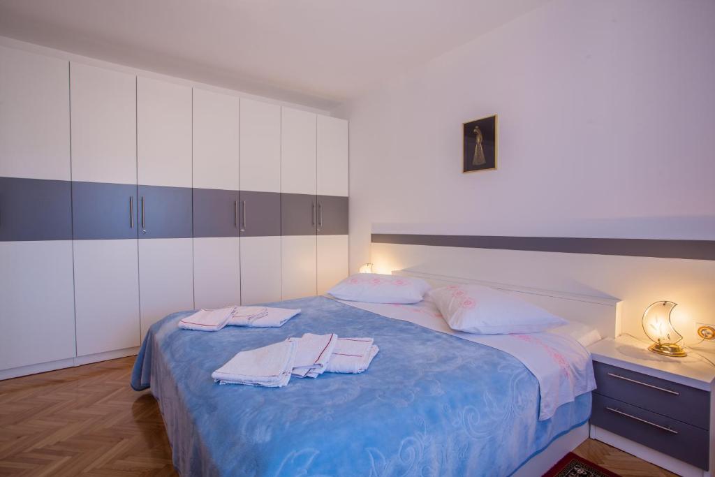 a bedroom with a bed with two towels on it at Rooms Kučić in Cres