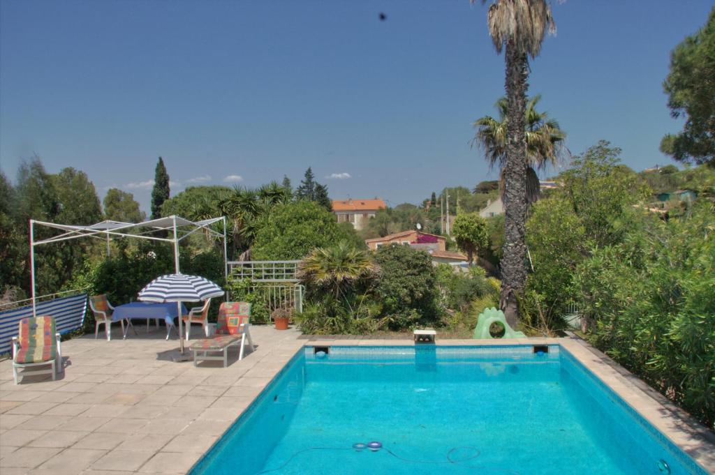 - une piscine et une terrasse avec une table et des chaises dans l'établissement Presqu`ile de Giens, à Hyères