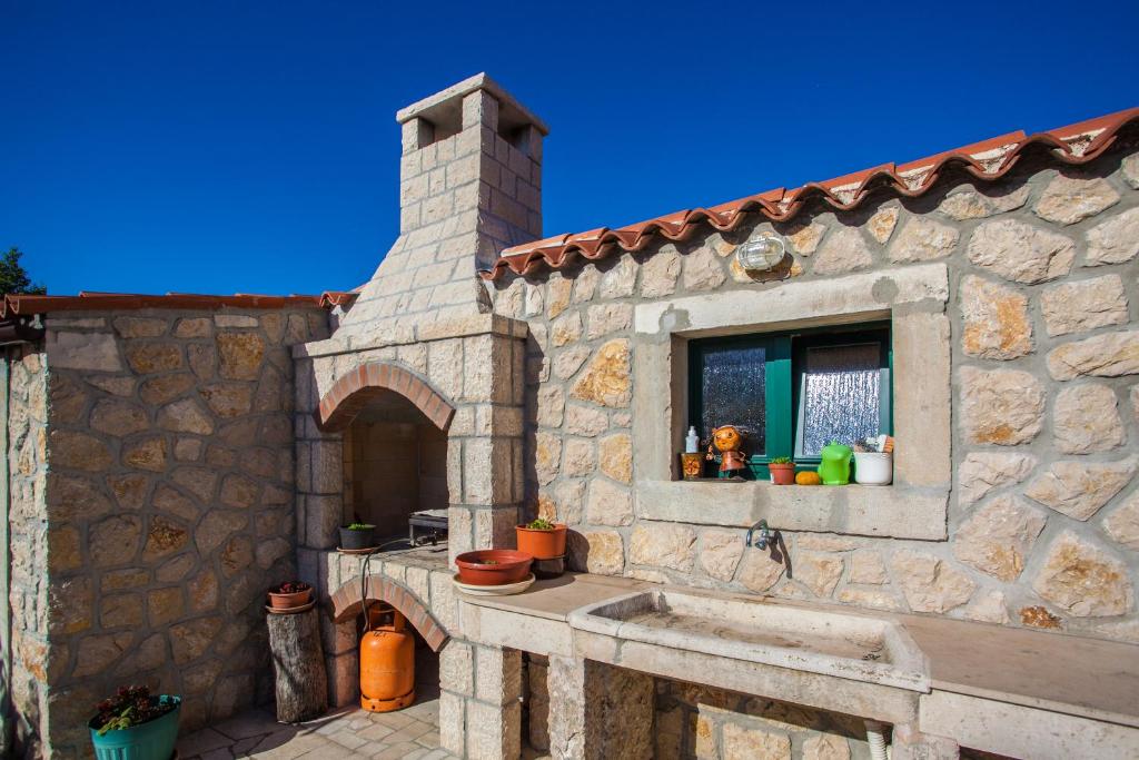 a stone house with a sink and a window at Rooms Kučić in Cres