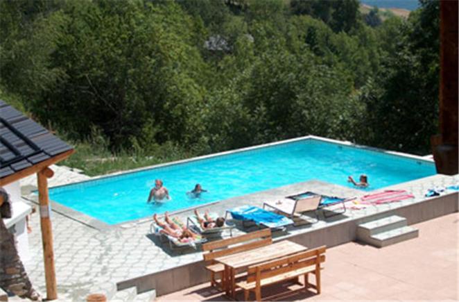a swimming pool with people in the water at Residence Selika in Leuk