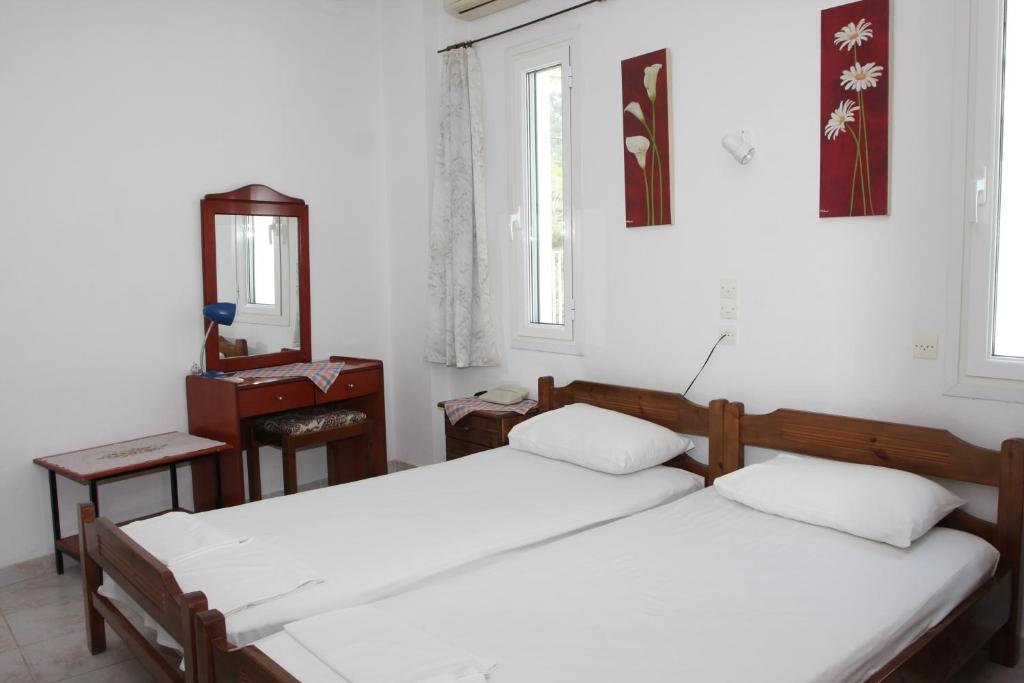 A bed or beds in a room at Akrogiali Hotel