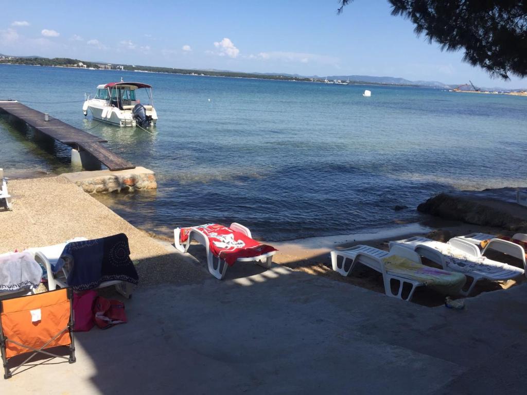 a boat is docked at a dock in the water at Apartmani MM in Tkon