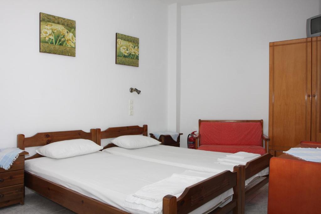 A bed or beds in a room at Akrogiali Hotel
