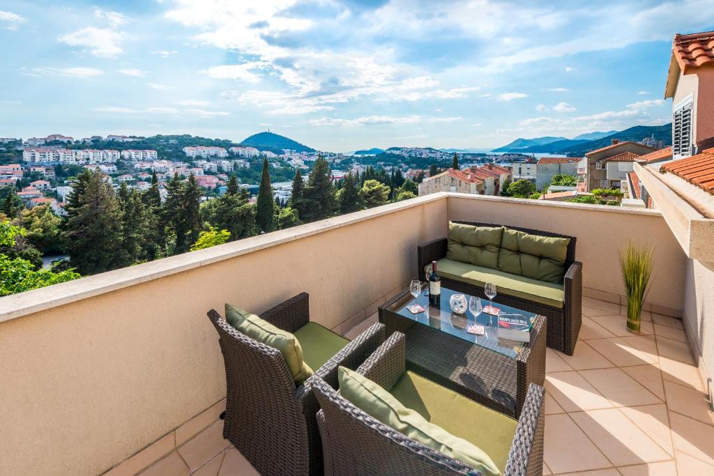 balcón con mesa, sillas y vistas en Sunlit Comfort Apartments, en Dubrovnik