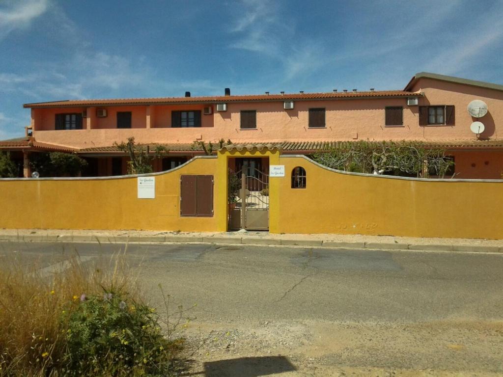 a yellow building with a door in front of a street at Hotel Su Giudeu in Chia