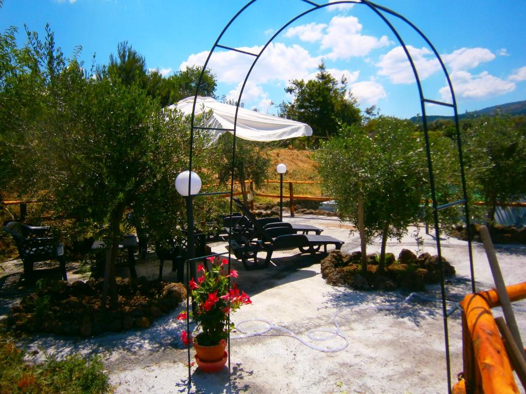 カスティリオーネ・ディ・シチーリアにあるVilla Lucia Tra Etna e Il Mare di Taorminaの木々や花々が植えられたパティオ(椅子、テーブル付)