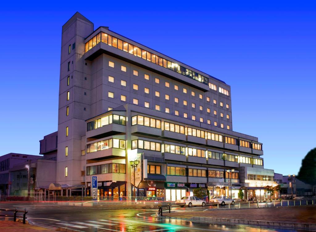 a tall building with lights on in a city at Hotel Montoview Yonezawa in Yonezawa