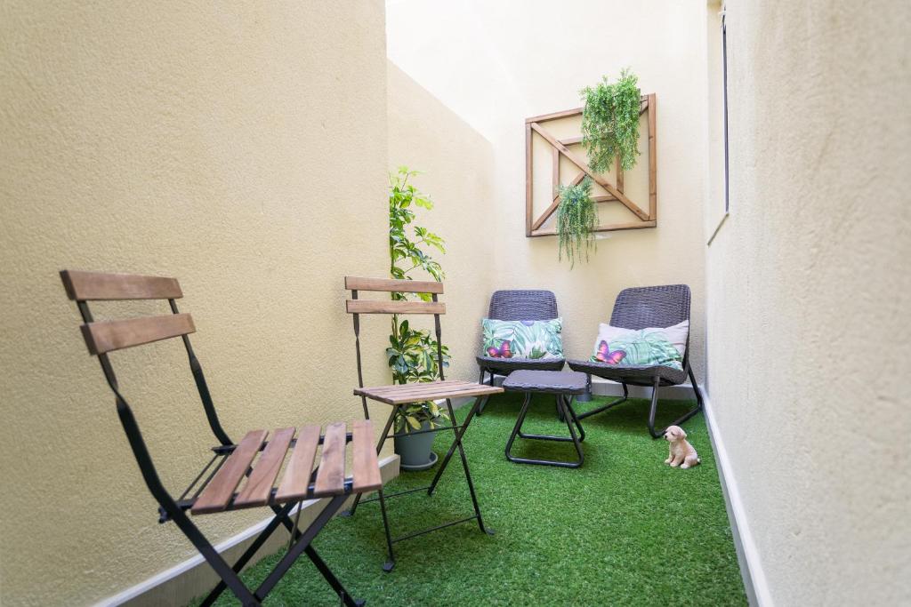 マラガにあるViento FreshApartments by Bossh Apartmentsの芝生のある部屋(椅子3脚、ベンチ付)