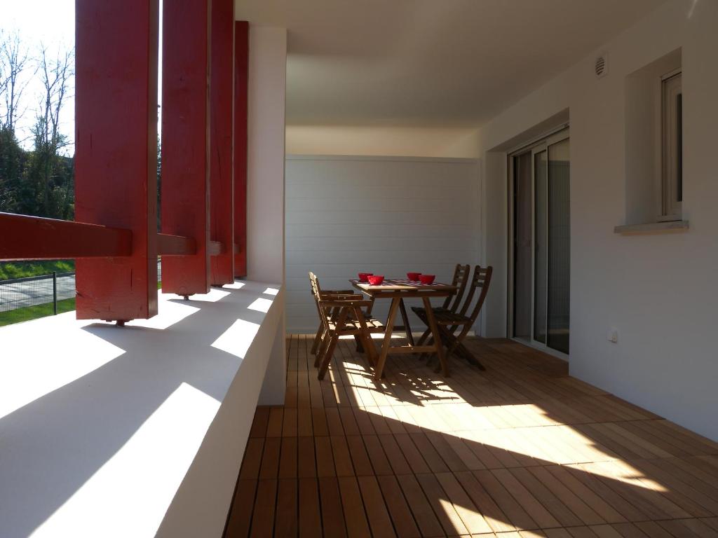 a dining room with a table and chairs on a balcony at HENDAYE- T2 3*-Wifi-350m plage-terrasse-garage in Hendaye