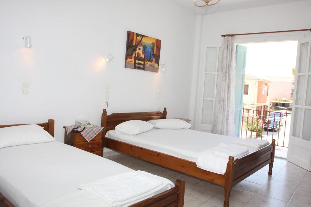 A bed or beds in a room at Akrogiali Hotel