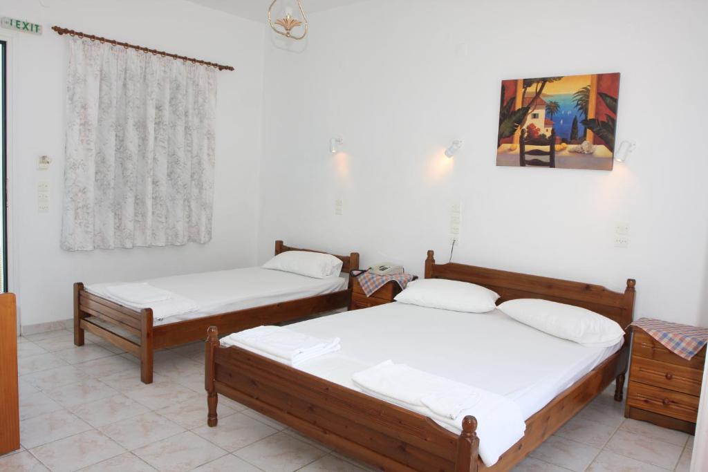 A bed or beds in a room at Akrogiali Hotel