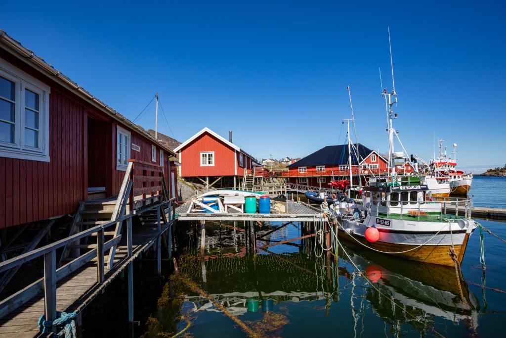 a couple of boats are docked at a dock at The Tide - Rorbuer in Sørvågen