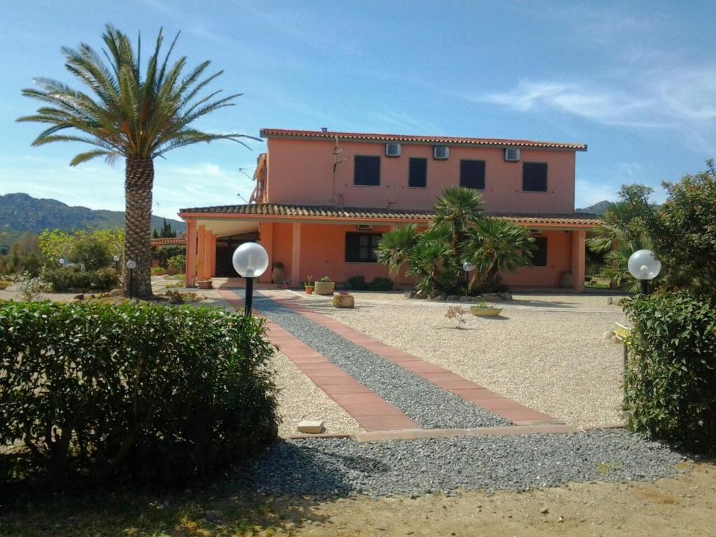 a house with a palm tree in front of it at Hotel Su Giudeu in Chia