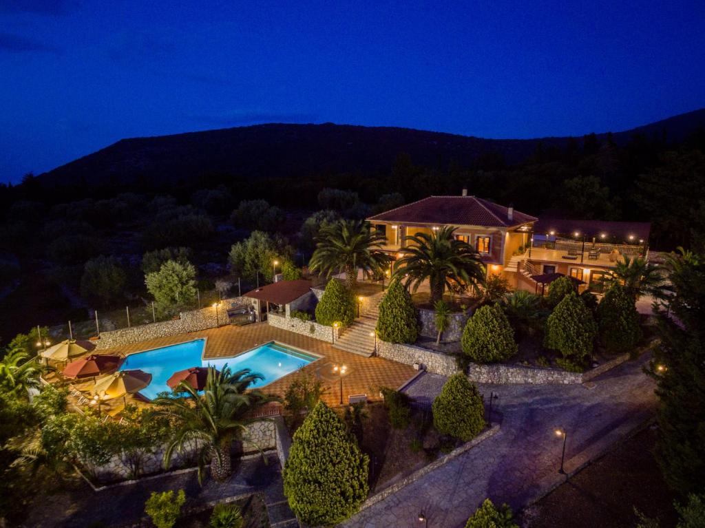 uma vista aérea de uma casa com uma piscina à noite em Mazourka em Stavros