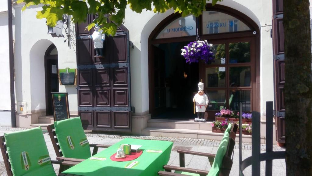 un tavolo verde con sedie di fronte a un edificio di Penzion u modrého zvonku a Zlaté Hory