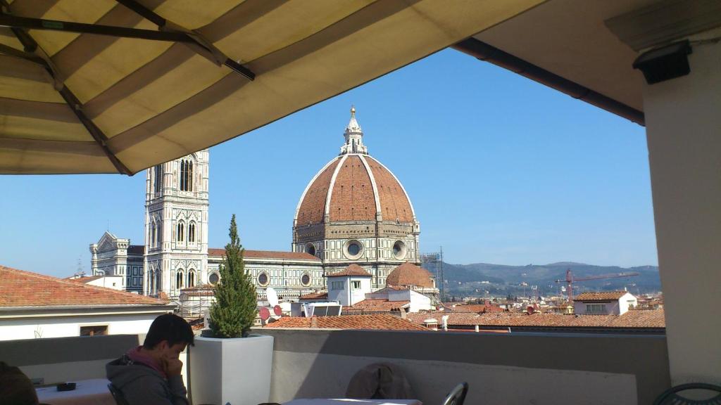 un hombre sentado en una mesa mirando un edificio en Il Duca Apartment, en Florencia