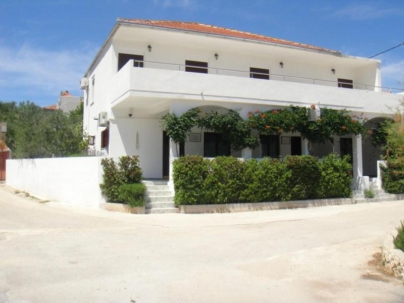 a white house with a staircase in front of it at Apartments Ivan Orlic in Vinišće